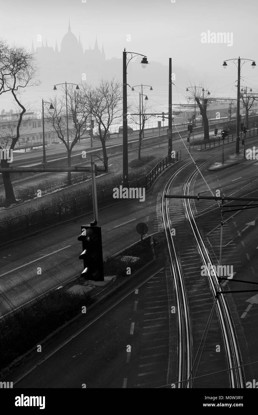 Railroad track crossing the street in Budapest with distant Parliament outline Stock Photo