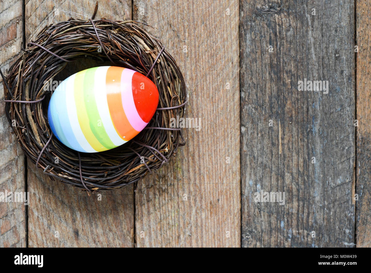 Easter eggs in nest on color wooden background Stock Photo - Alamy