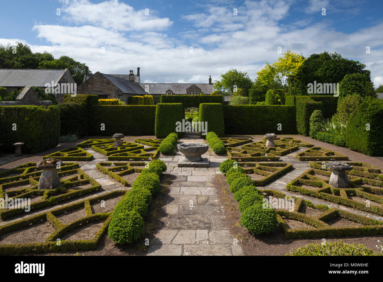 The view from the gazebo terrace of the 'fancy' garden with box parterre and stone Lavabo. Herterton House, Northumberland, England Stock Photo