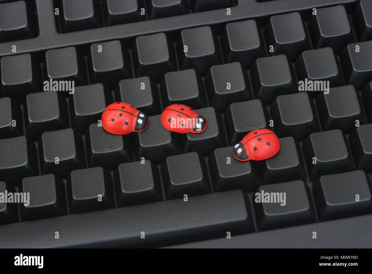 Small toy ladybird - as visual metaphor for concept of computer bugs, software bugs, hardware bugs, computer viruses. Stock Photo