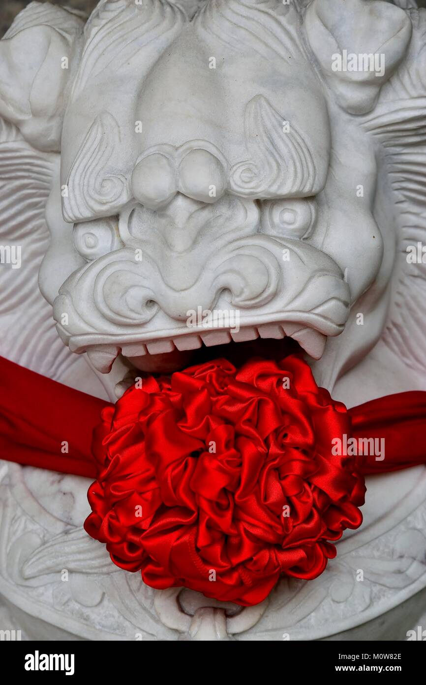 Traditional stone Chinese lion statue decorated with red silk to celebrate Chinese Lunar New Year. Stock Photo