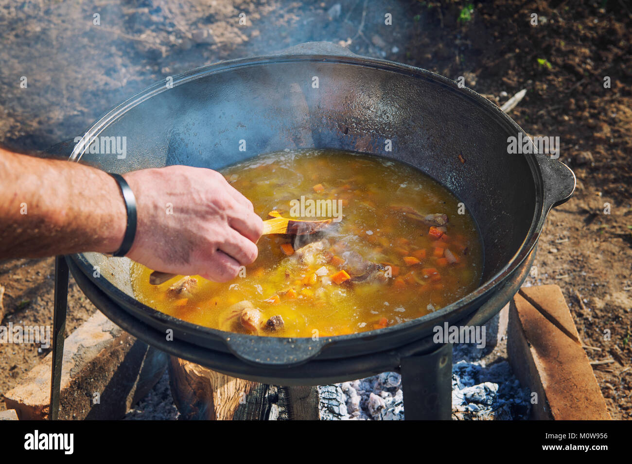 https://c8.alamy.com/comp/M0W956/cooking-pilaf-and-hush-in-a-big-pot-with-a-strong-steaming-on-an-open-M0W956.jpg