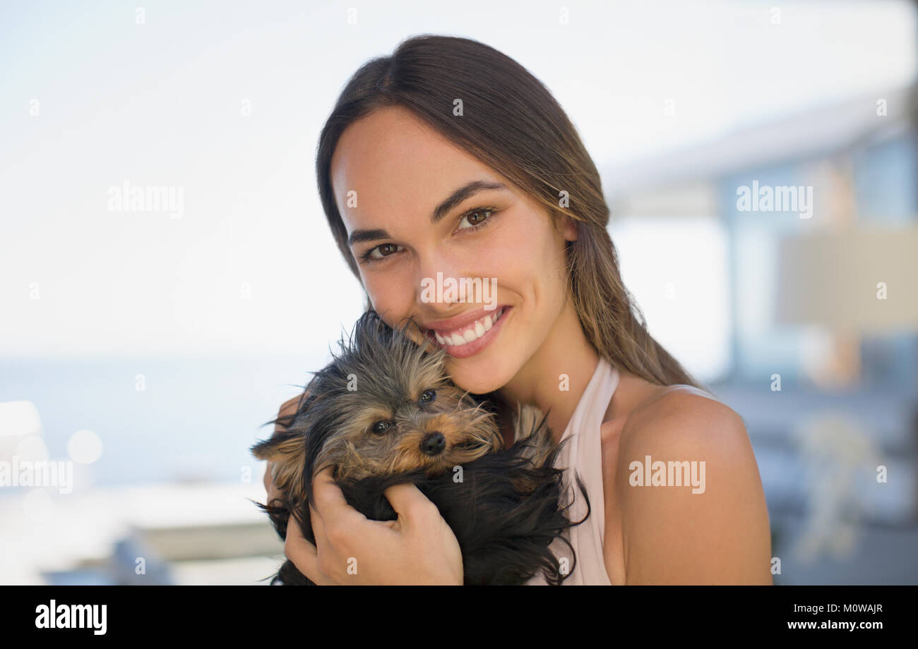 Portrait smiling woman cuddling small dog Stock Photo