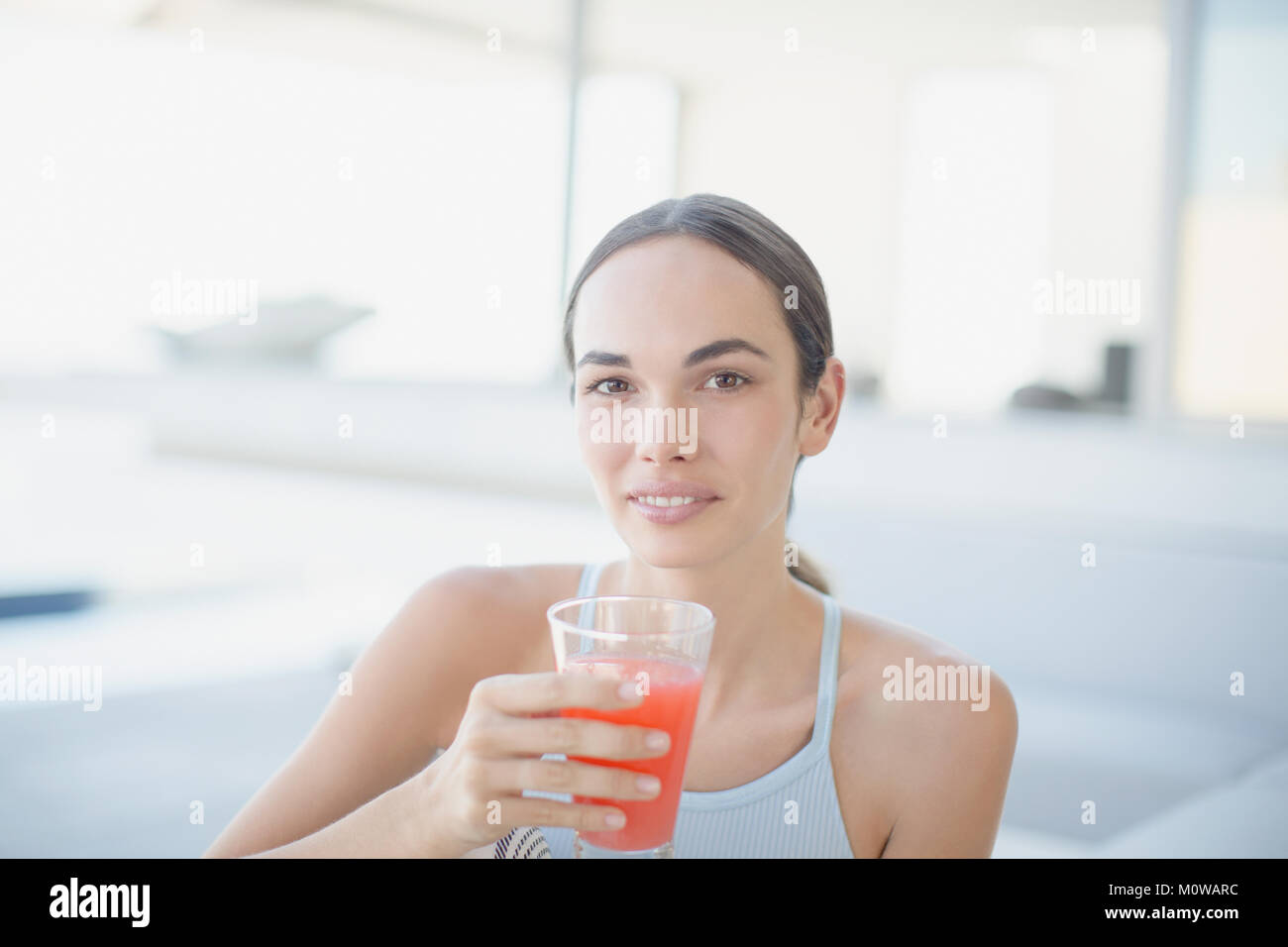 Portrait confident brunette woman drinking juice Stock Photo