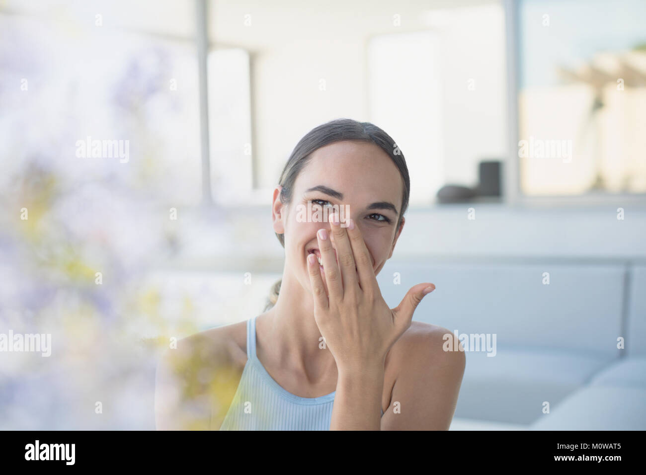 Laughing brunette woman covering mouth Stock Photo