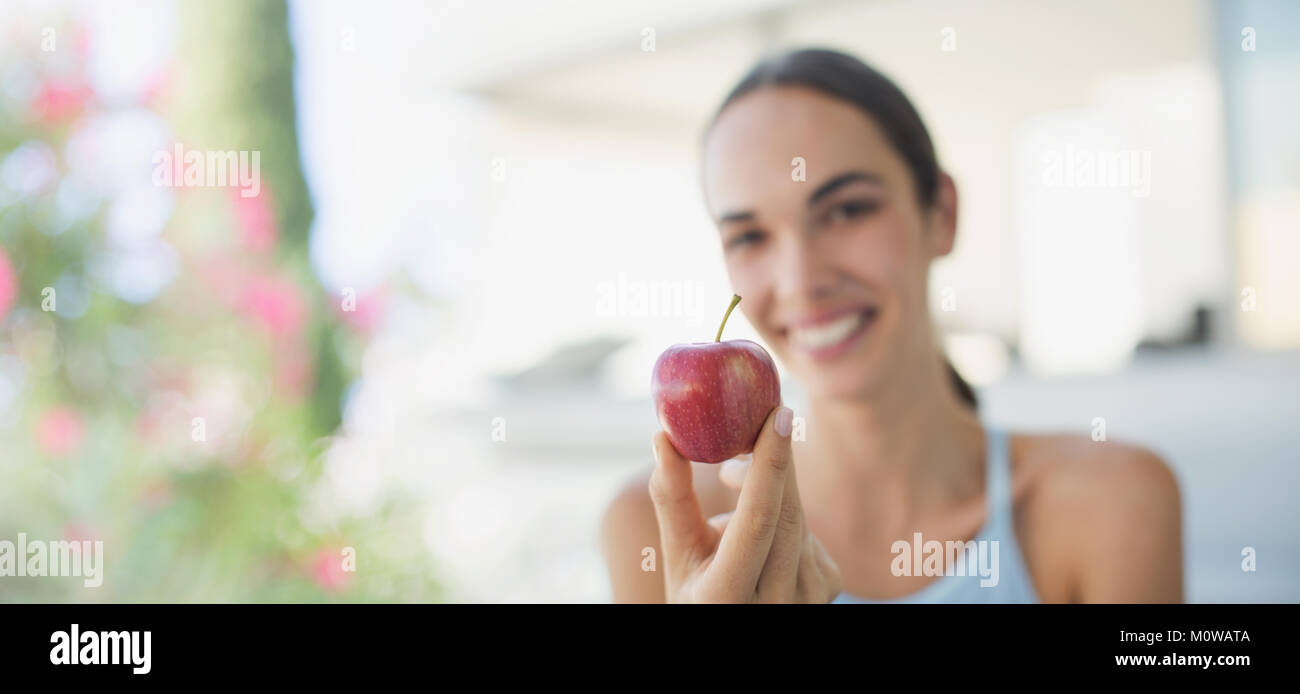 Portrait smiling brunette woman holding red apple Stock Photo