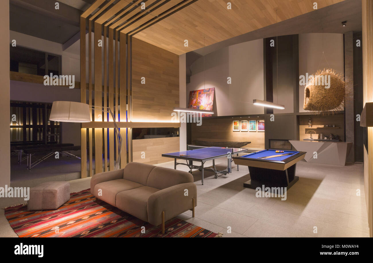 Illuminated pool table and ping pong table in modern, luxury home showcase interior game room