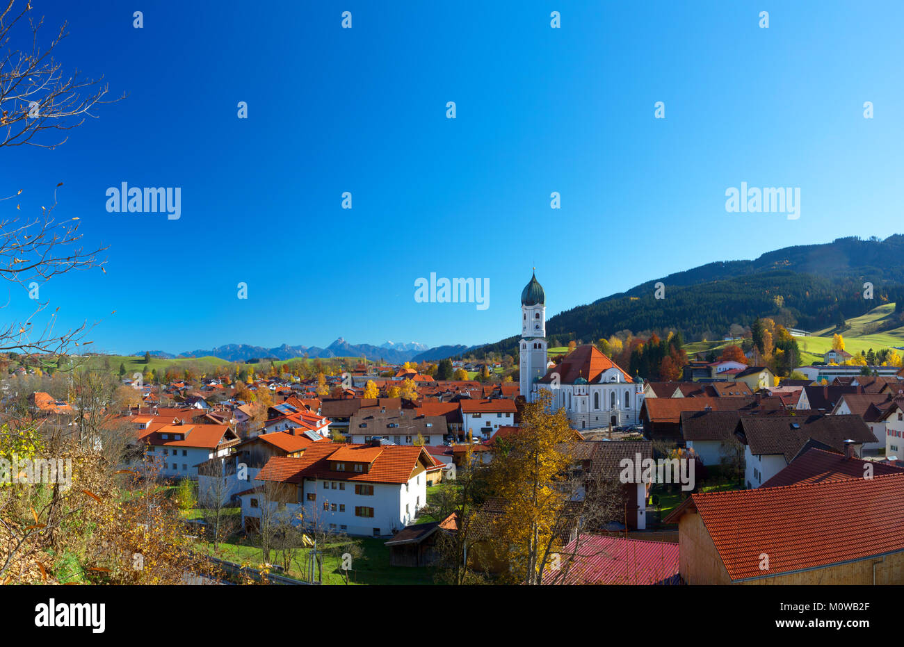 Blue sky in autumn over Nesselwang in Allgäu, Bavaria, Germany, with the alps in the background. Stock Photo