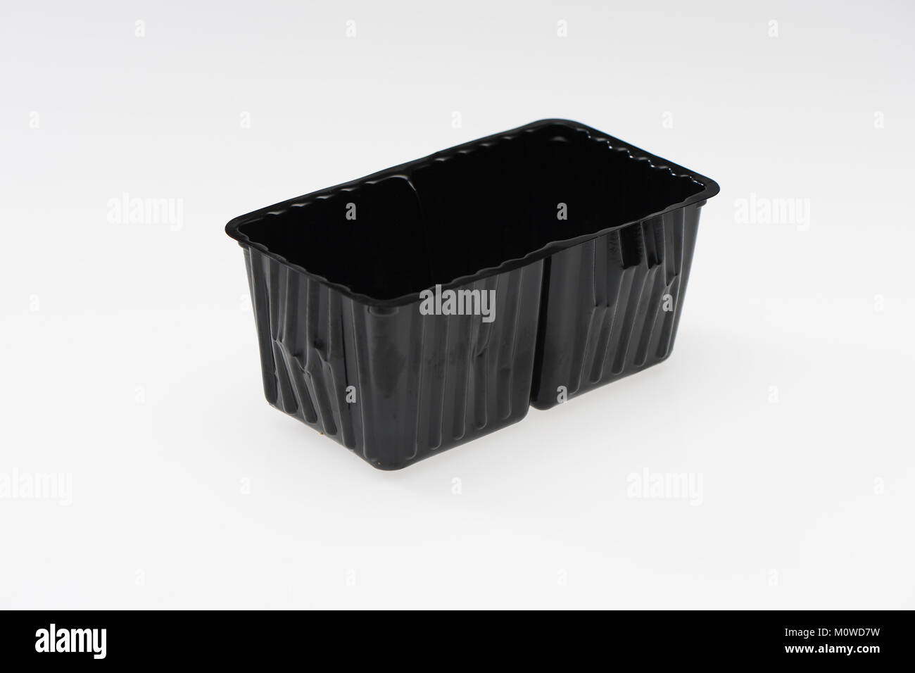 A black single use plastic food container ready for recycling on a white background. Stock Photo
