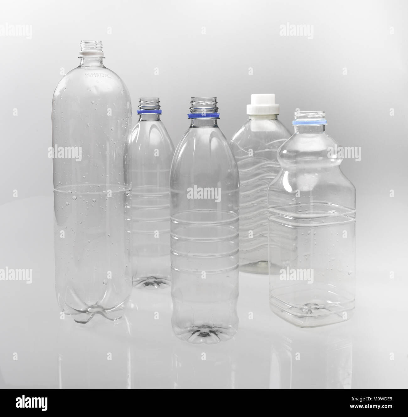 A range of empty clear plastic bottles on white background ready for recycling. Stock Photo