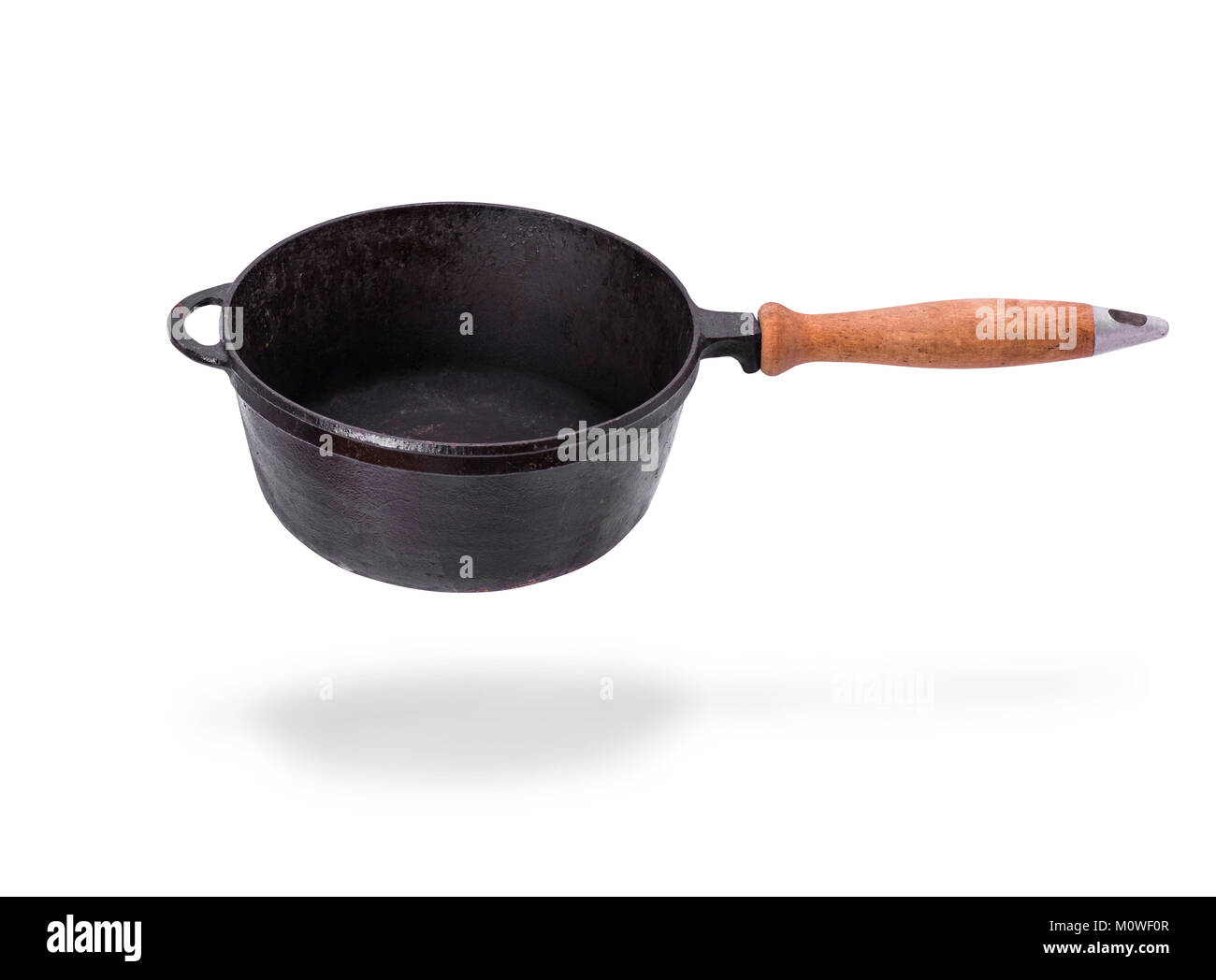 deep old black cast iron frying pan with wooden handle isolated on ...