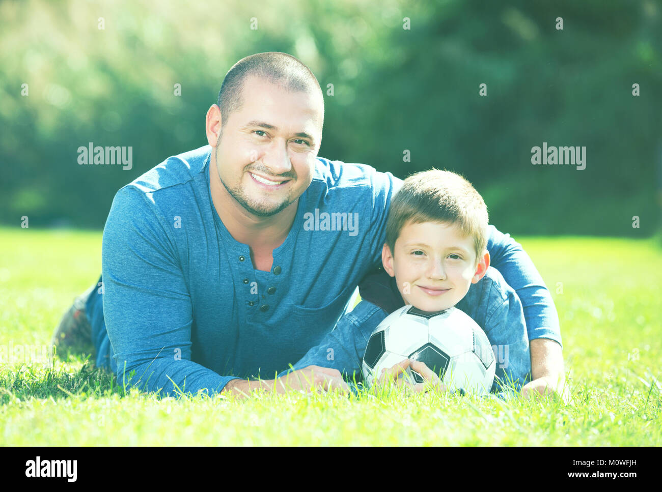 Portrait of father and son with soccer ball on grass Stock Photo - Alamy
