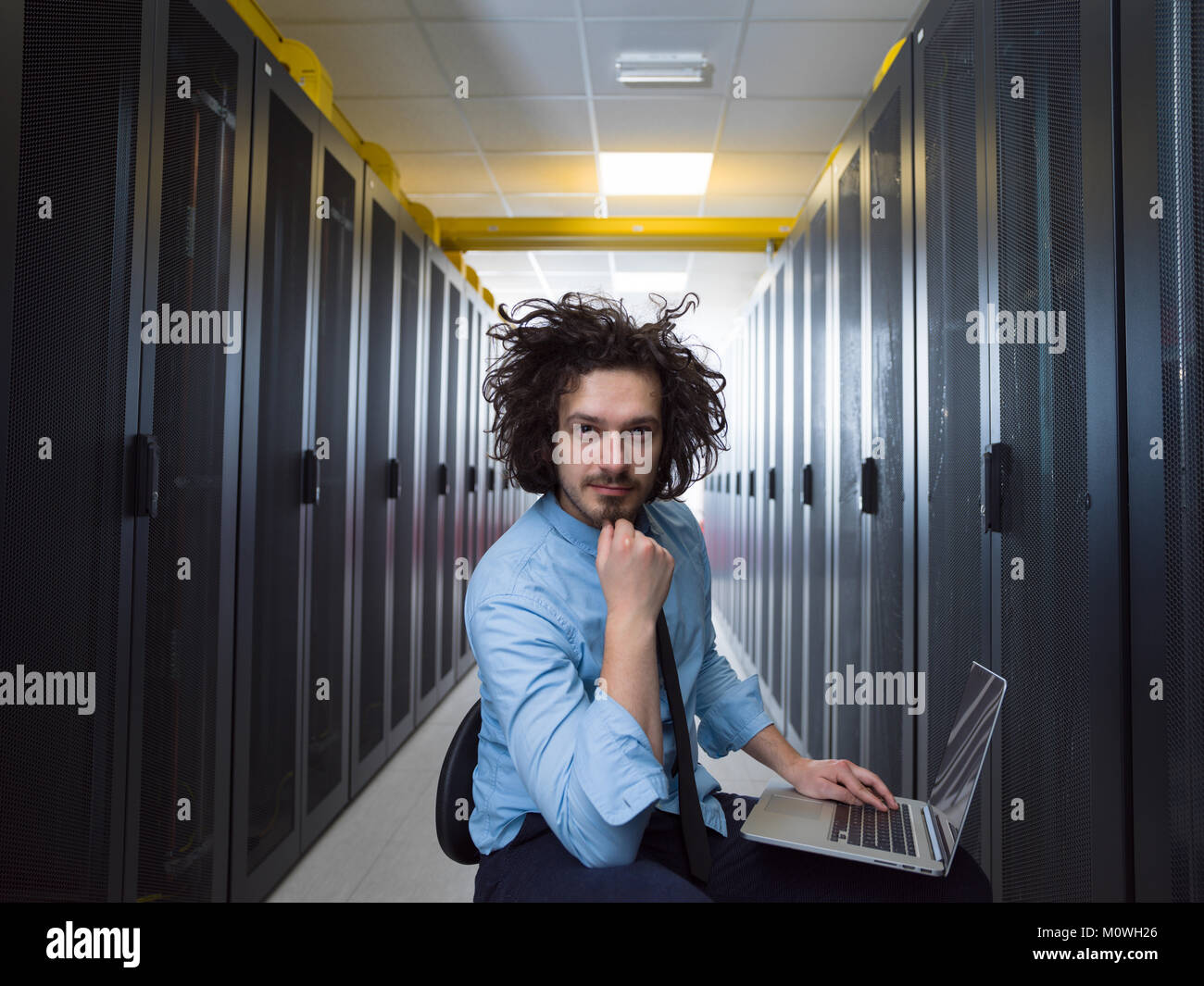 Male IT engineer working on a laptop in server room at modern data ...