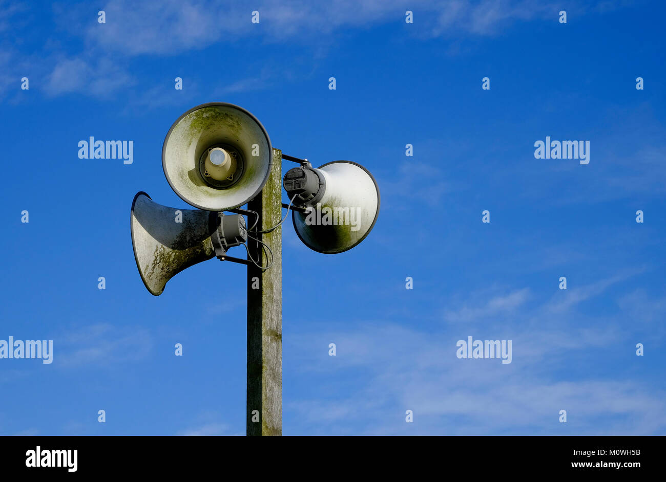 3 outdoor speakers mounted on timber post facing different directions Stock Photo