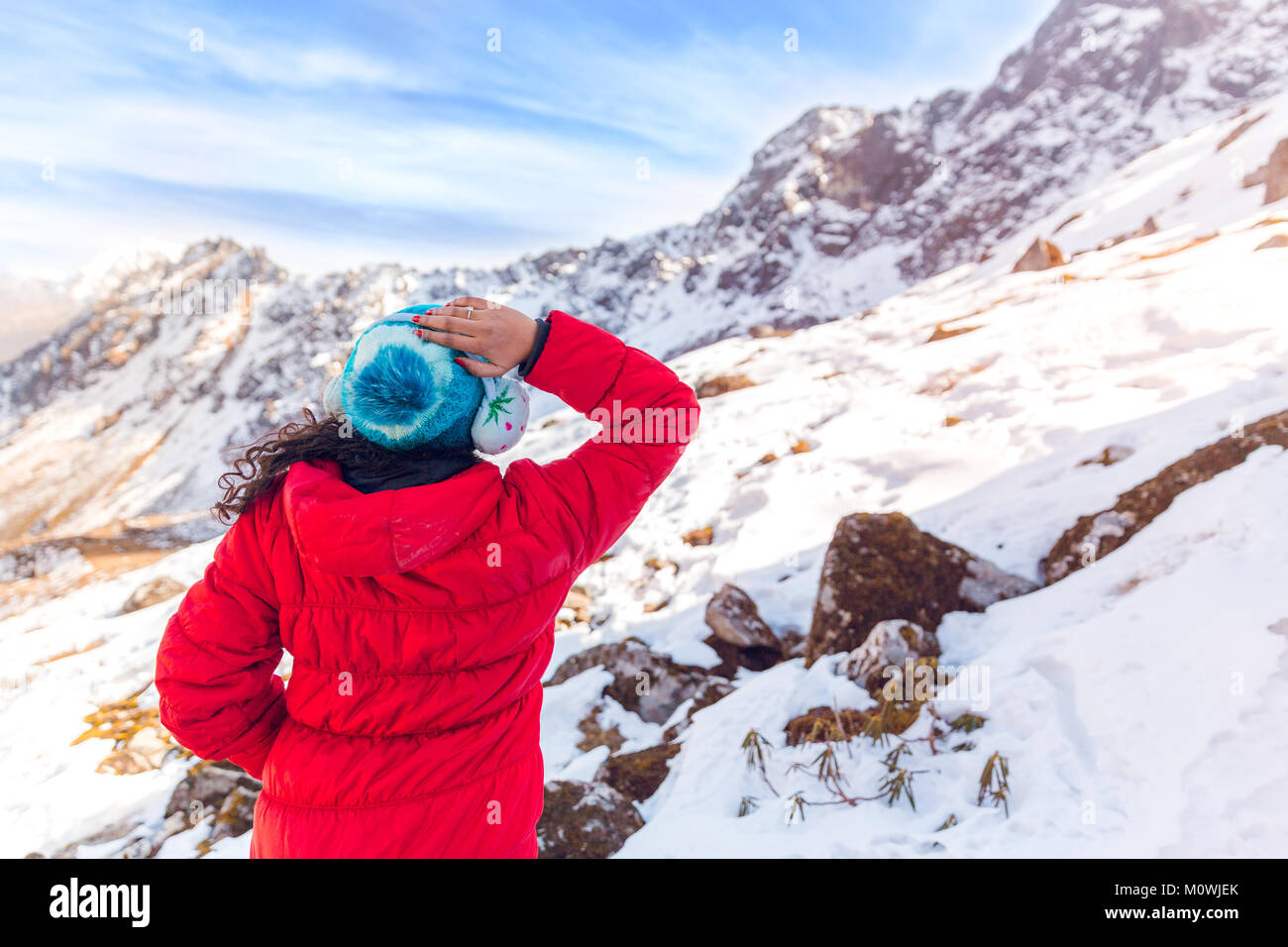 A tourist enjoys snowfall at Chopta valley, Kalapathar in North Sikkim, India in cold winter. Snow covered mountain peaks in north east part of India. Stock Photo