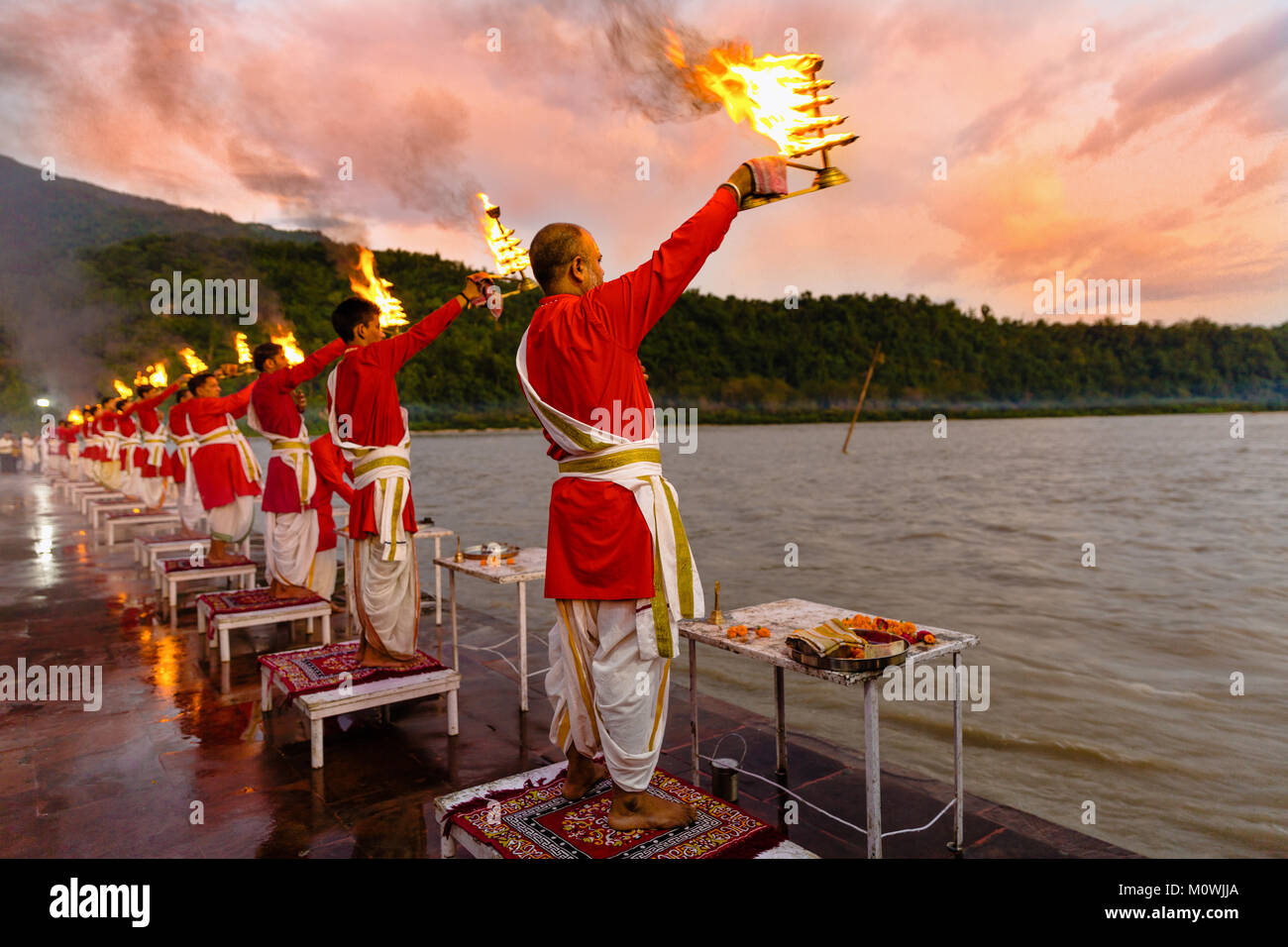 Rishikesh, Uttarakhand - August 03 2016: Priests in red robe in the holy city of Rishikesh in Uttarakhand, India during the evening light ceremony Stock Photo
