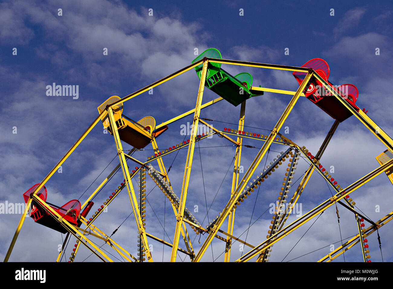 Colourful seats on top of a ferris wheel Stock Photo