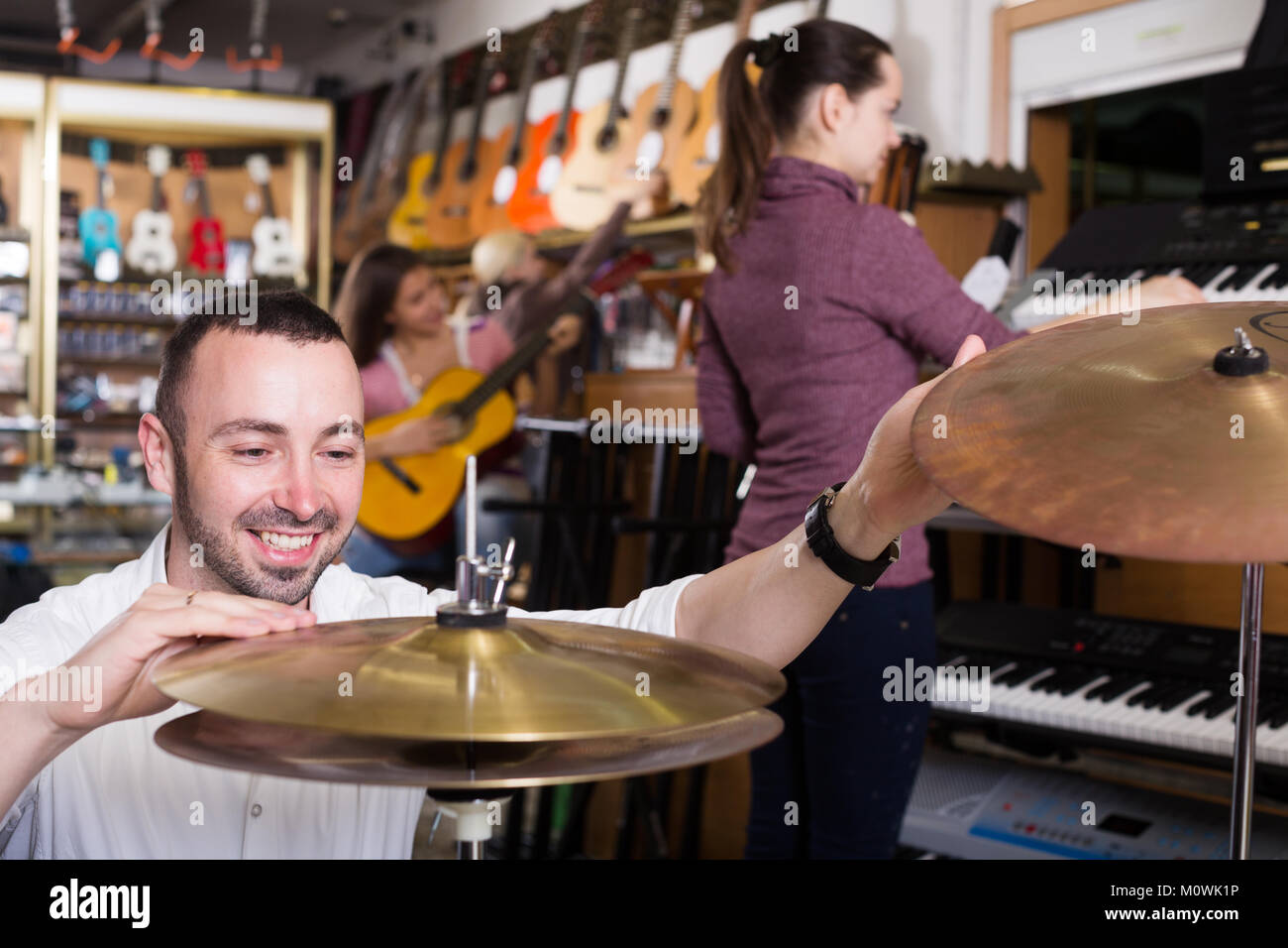 Clients looking at professional musical instruments in store Stock