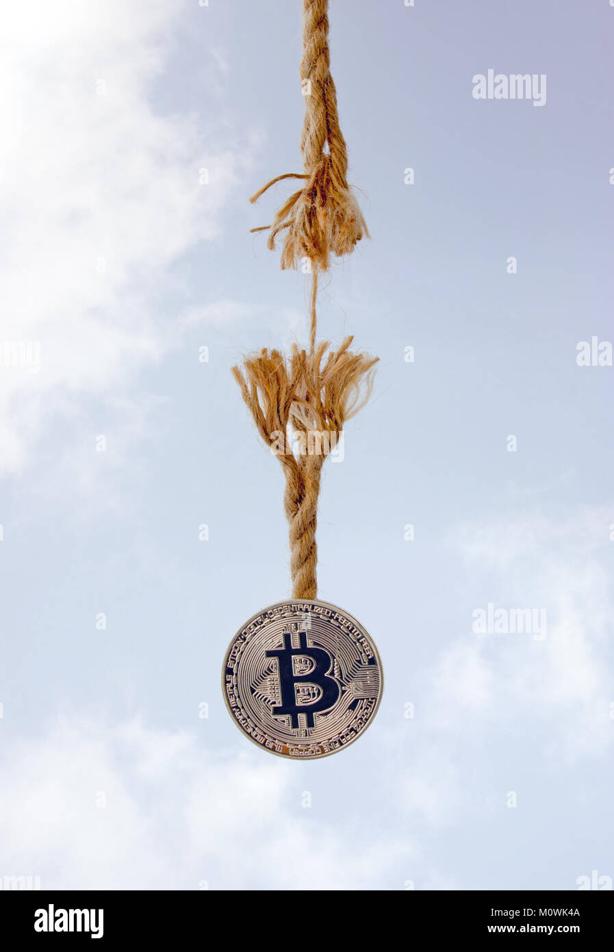 Crypto currency is hanging on the thread of a rope, which will soon be  broken. The background is a blue sky with white clouds Stock Photo - Alamy