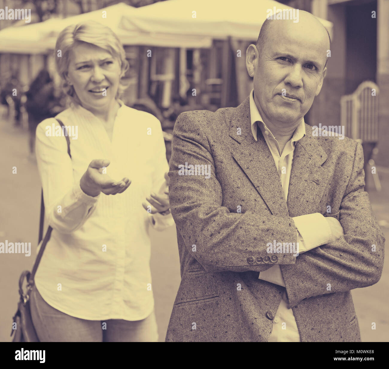 irritated senior man standing back to annoyed woman outdoors Stock ...