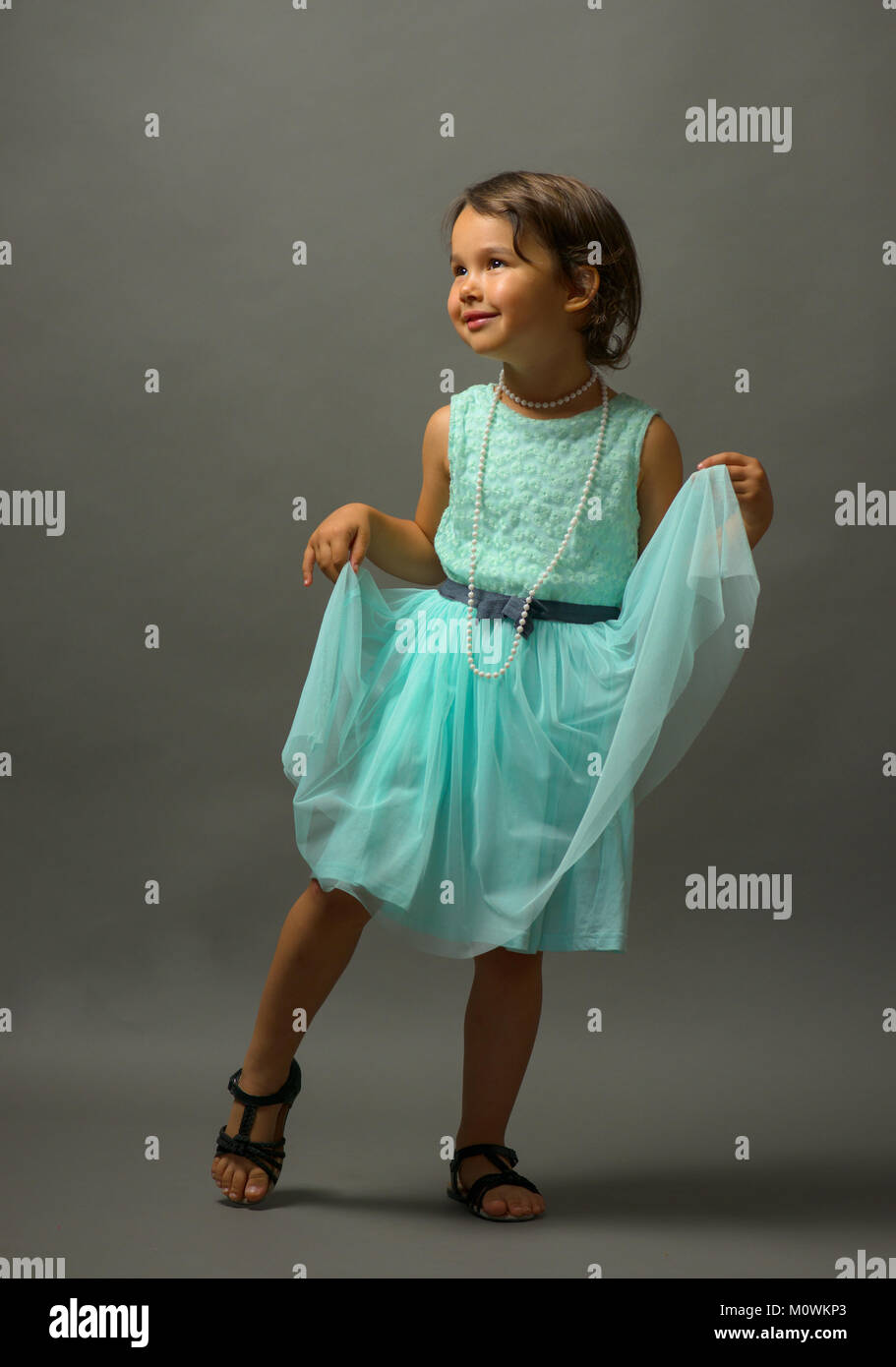 Little cute girl dancing  on gray background Stock Photo