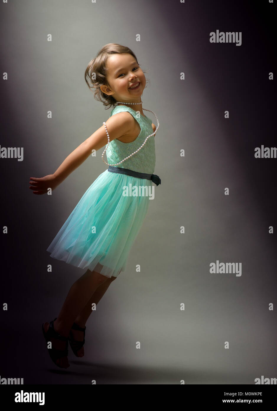 Little cute girl dancing  on black background Stock Photo