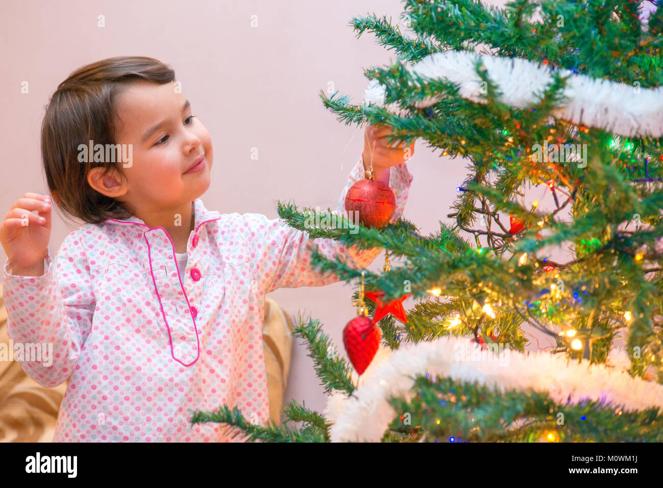 Cute little girl at chrismass tree Stock Photo - Alamy