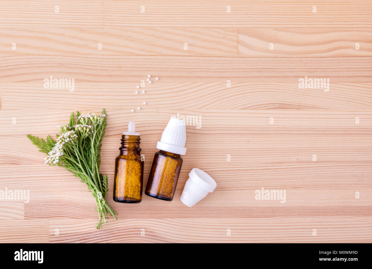 Top view of Homeopathic remedy with flowering yarrow with a wooden background Stock Photo