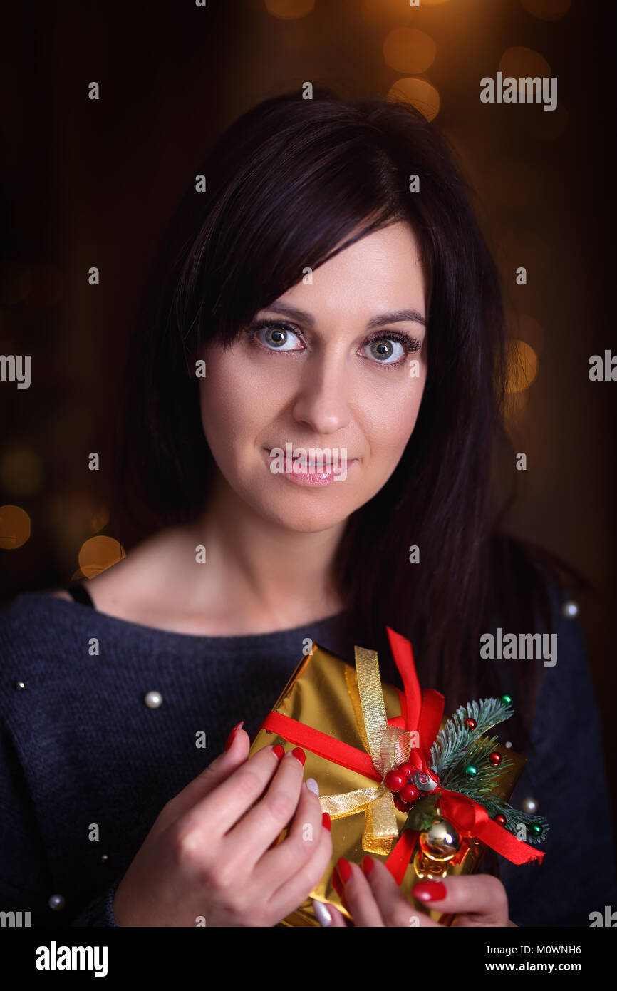 Young beautiful girl holding a Christmas present Stock Photo - Alamy