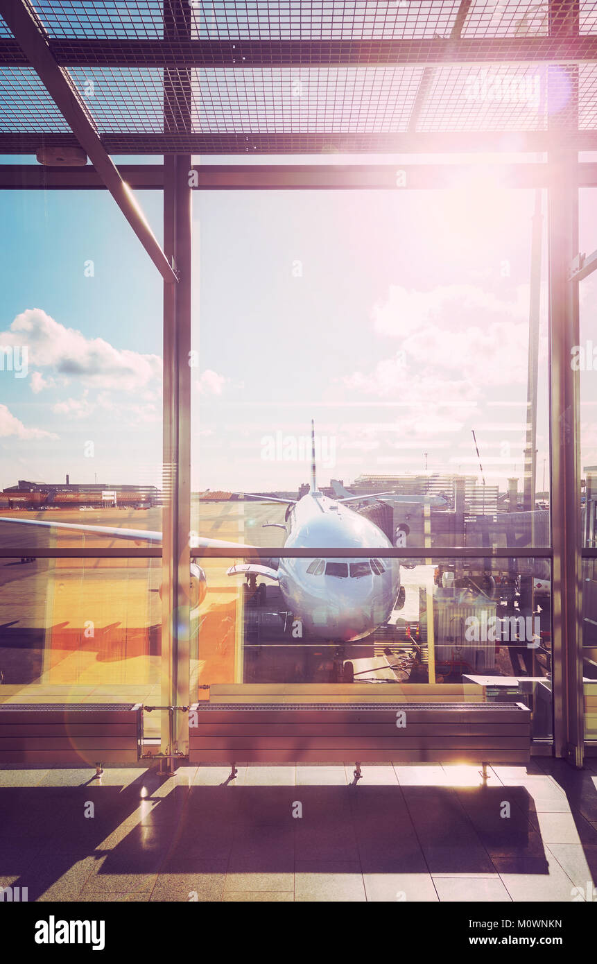 Departure hall at an airport at sunset, color toned travel and transportation concept picture with lens flare effect. Stock Photo