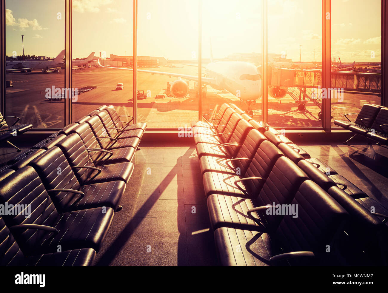 Empty seats in an airport departure hall at sunset, color toned picture, travel and transportation concept. Stock Photo
