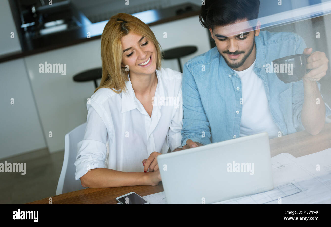 Photo of cheerful loving young couple using laptop Stock Photo - Alamy