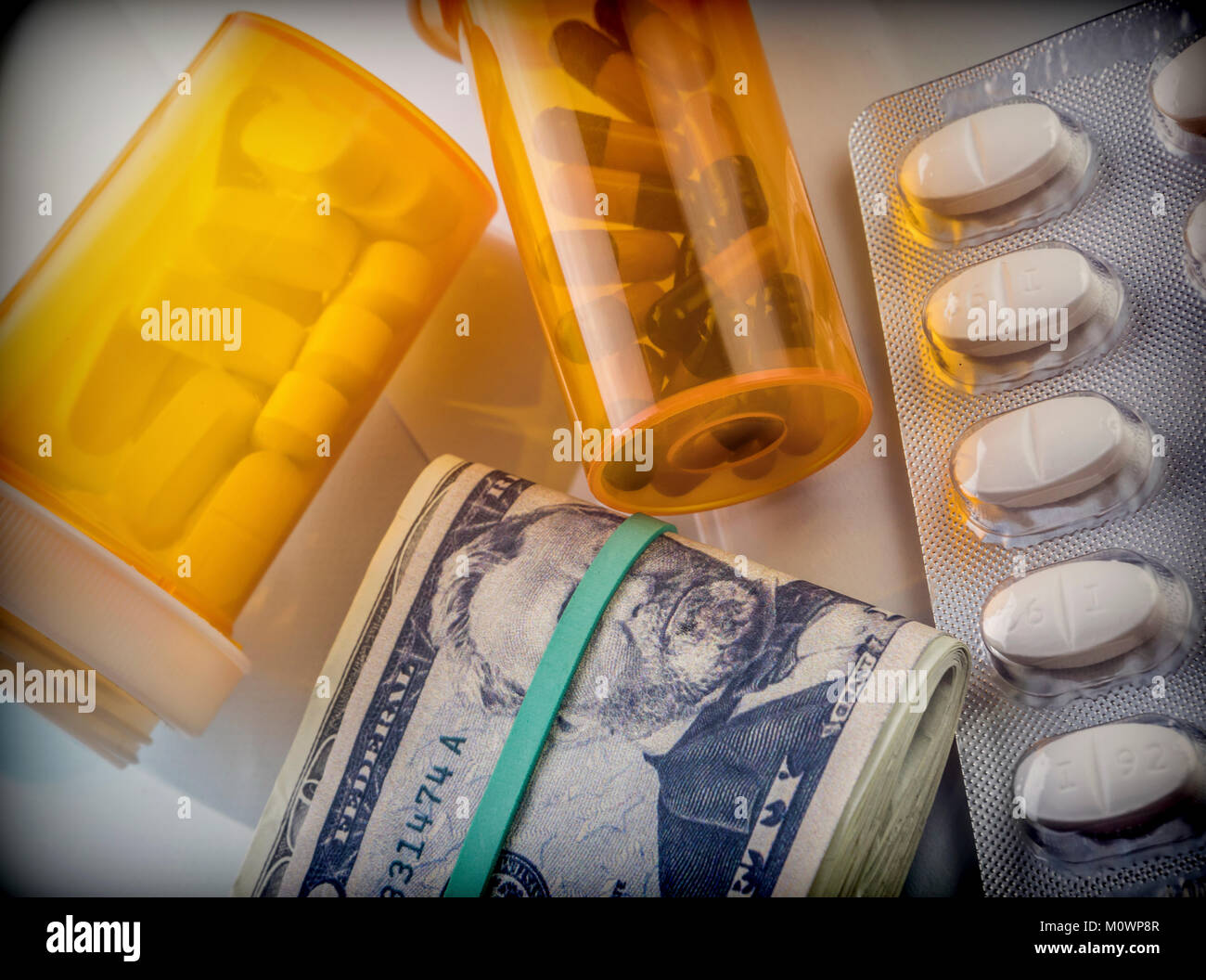 Some medicines next to a block of tickets of dollar, conceptual image Stock Photo