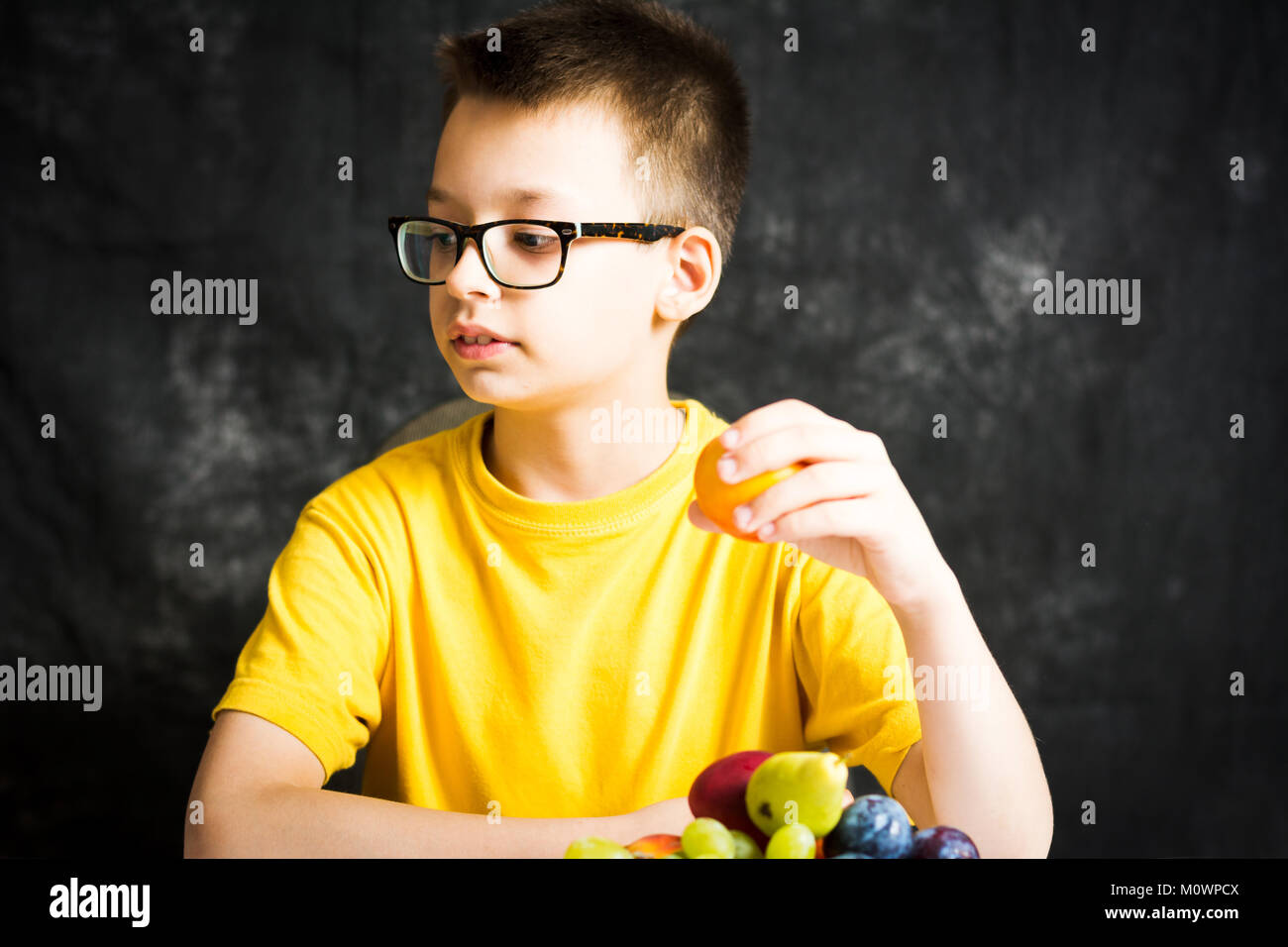 Teenage boy eating fruit for a healthy snack Stock Photo Alamy