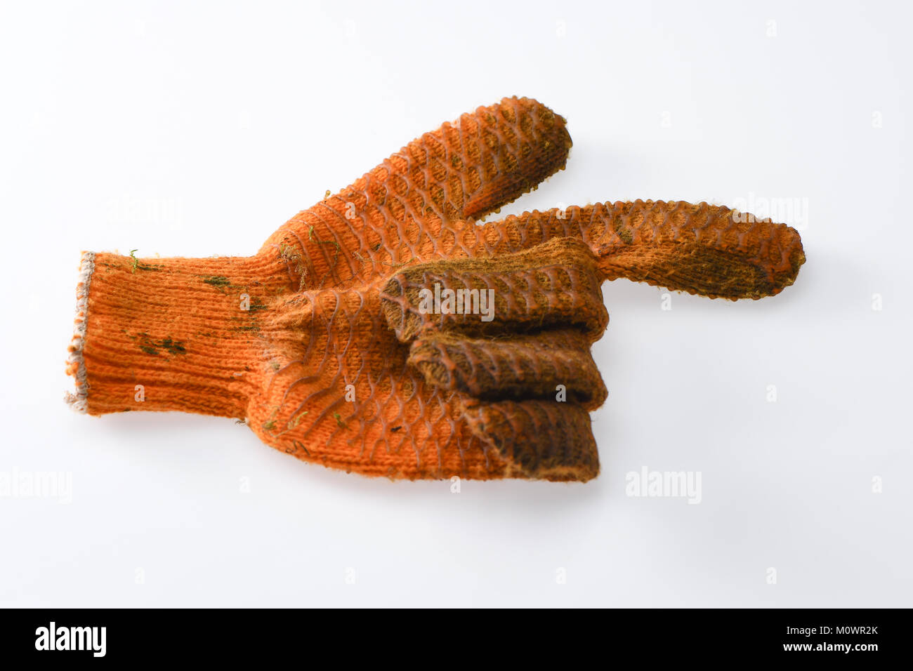 A empty left hand orange dirty gardening glove pointing with finger to the right direction on a white background. Stock Photo