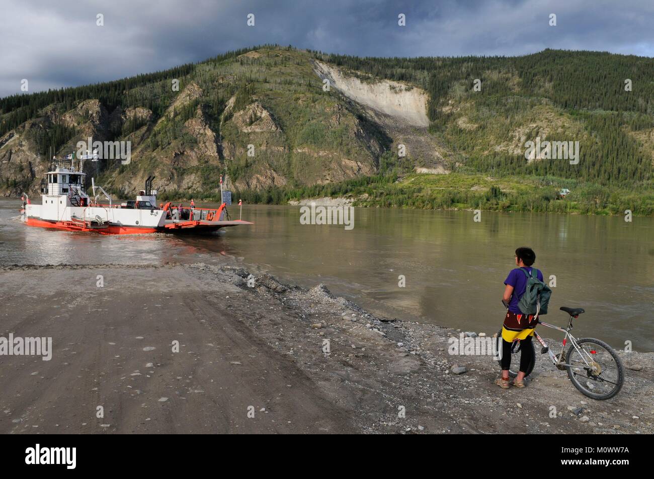 Canada,Yukon Territory,Dawson City,cyclist waiting for ferry to cross Yukon River Stock Photo