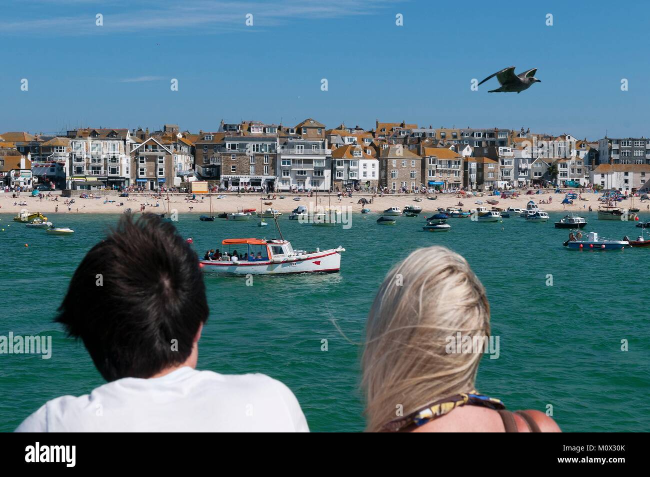 United Kingdom,Cornwall,Saint Ives,couple looking towards the boats and beach Stock Photo