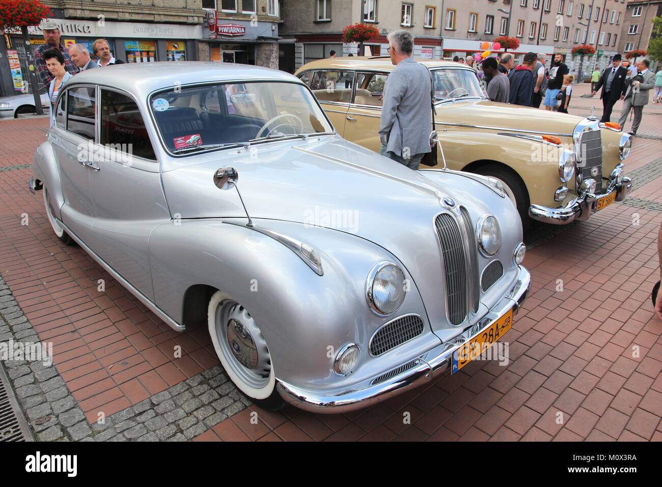 BYTOM, POLAND - SEPTEMBER 12, 2015: People walk by BMW 501 and Mercedes-Benz 300 oldtimer cars during 12th Historic Vehicle Rally in Bytom. Stock Photo