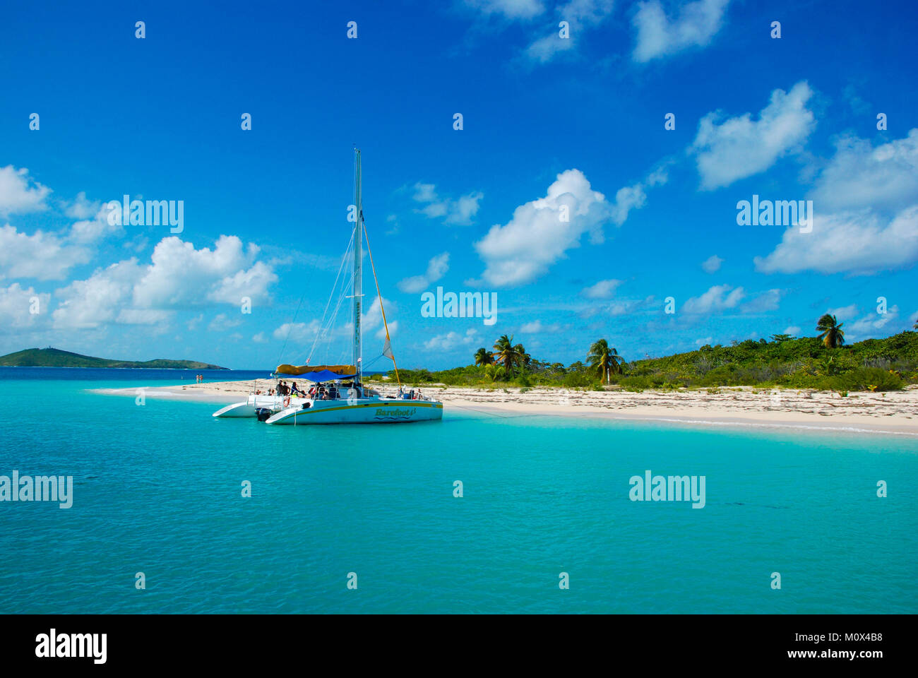 The uninhabited Caribbean island, Cayo icacos, in Puerto Rico, that forms part of the Cordillera Keys Nature Reserve with catamaran boat moored Stock Photo