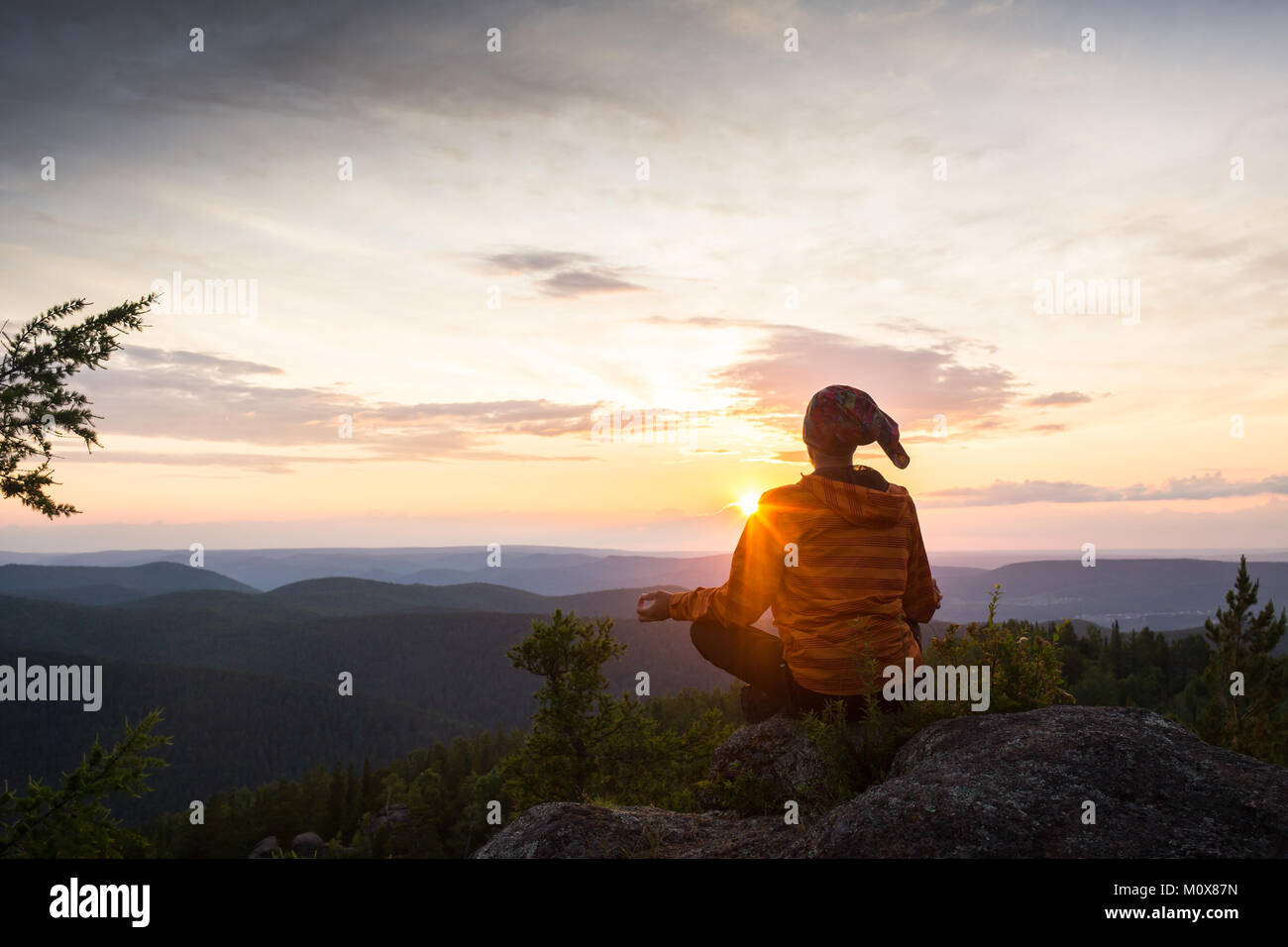 man meditating on a rock Stock Photo - Alamy