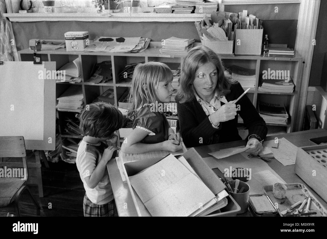 Village Primary school 1970s England. Cheveley Cambridgeshire 1978 UK. Schoolchildren coming up to the teachers desk at the front of the classroom and getting instructions.  HOMER SYKES Stock Photo