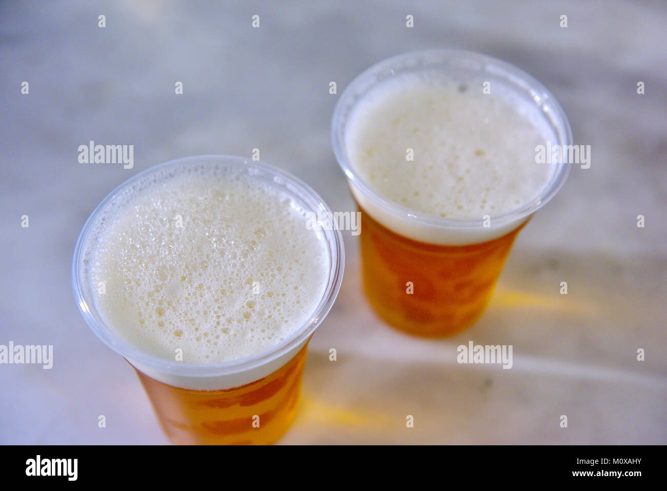Two beers in clear plastic cups Stock Photo