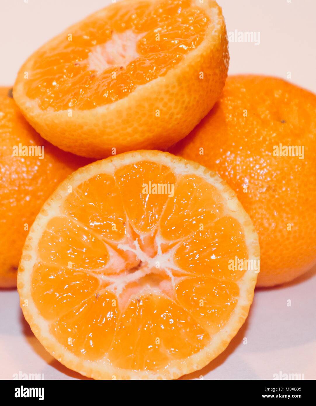 Orange tangerine clementine cut in half juicy healthy snack Stock Photo