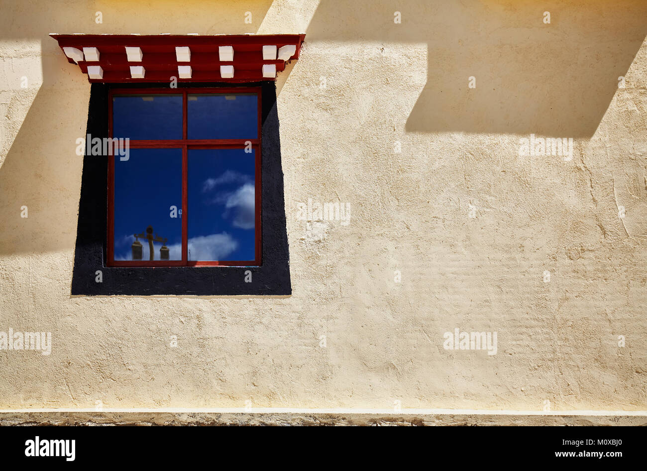 Old wall with window painted in Tibetan style, space for text, China. Stock Photo