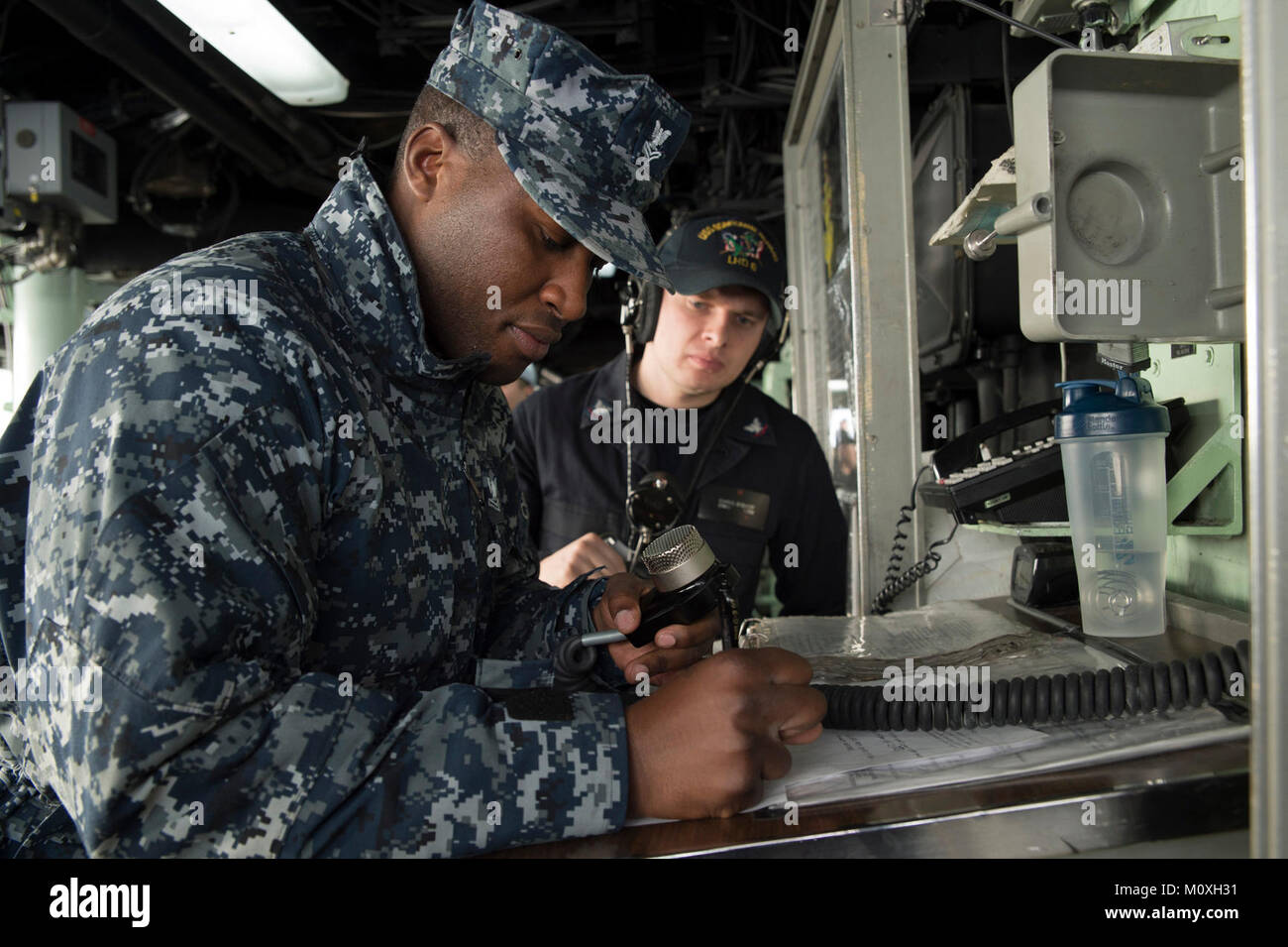 SASEBO, Japan (Jan. 19, 2018) Boatswain’s Mate 2nd Class Jonathan Cole, records time-in-water for a man overboard during a drill on the bridge of the amphibious assault ship USS Bonhomme Richard (LHD 6). Bonhomme Richard, forward-deployed to Sasebo, Japan, is serving forward to provide a rapid-response capability in the event of a regional contingency or natural disaster. (U.S. Navy video by Mass Communication Specialist 2nd Class Diana Quinlan/Released) Stock Photo