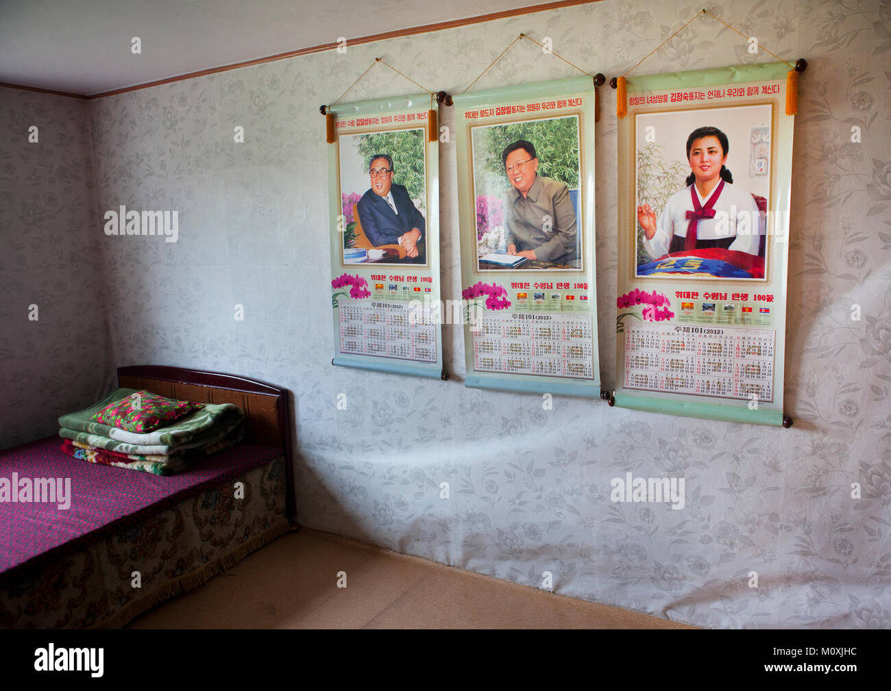 Bedroom in a North Korean house with the Dear Leaders portraits on the wall, South Hamgyong Province, Hamhung, North Korea Stock Photo