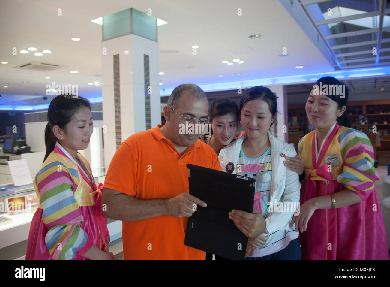 French tourist showing his ipad to saleswomen in the former meeting point between families from North and south, Kangwon-do, Kumgang, North Korea Stock Photo