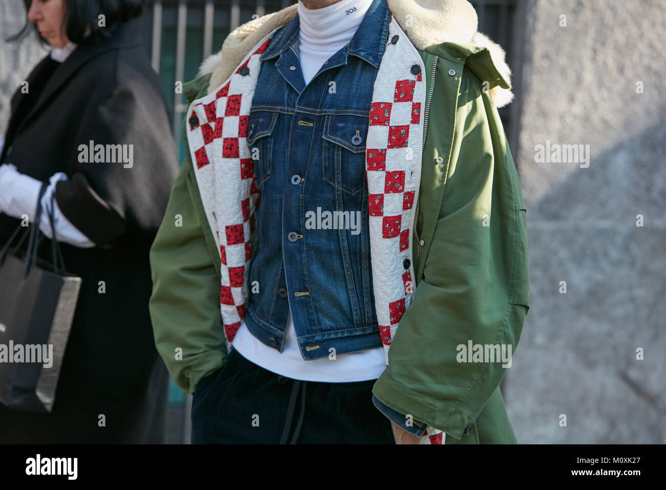 MILAN - JANUARY 13: Man with green parka and blue jeans jacket before Emporio Armani fashion show, Milan Fashion Week street style on January 13, 2018 Stock Photo