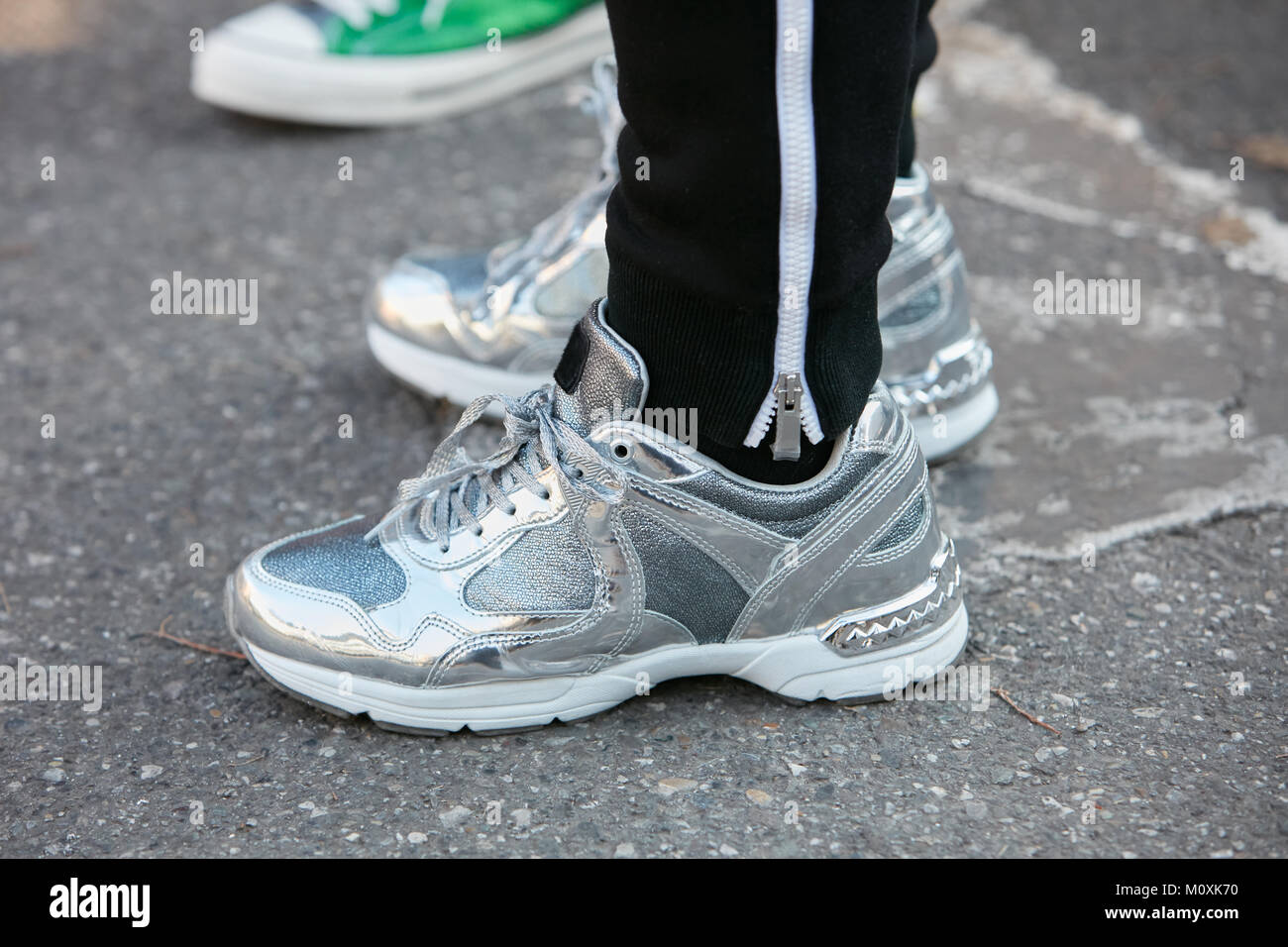 MILAN - JANUARY 13: Woman with silver sneaker shoes before Diesel Black  Gold fashion show, Milan Fashion Week street style on January 13, 2018 in  Mila Stock Photo - Alamy