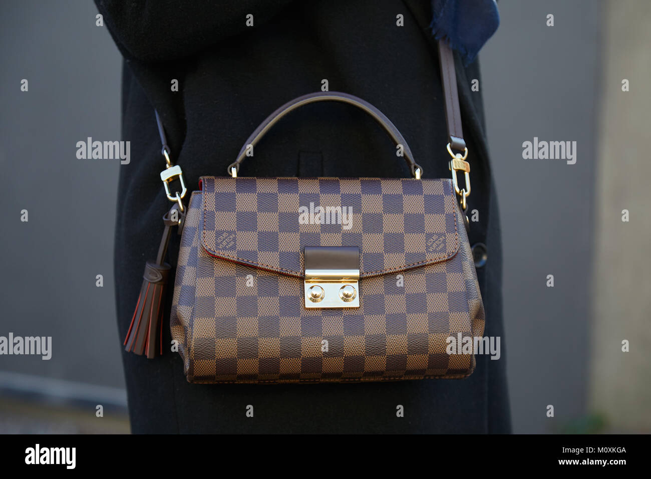 Woman with gray and white checkered Louis Vuitton bag on June 15, 2018 in  Milan, Italy Stock Photo